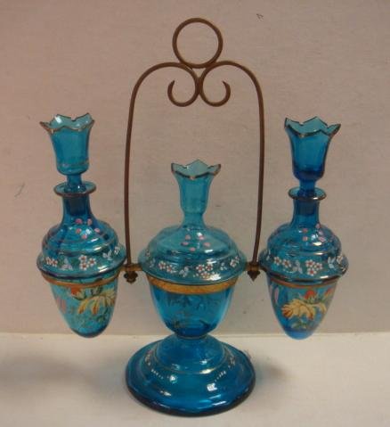 Unusual Victorian Blue Glass and Enamel Vanity Set:: Unusual Victorian Blue Glass and Enamel Vanity Set: Three Piece Set has 2 Rounded Bottom 9"T Perfume Bottles with Stoppers that Could be Used as Candle Holders. Center Lidded Jar has Attached Holder f