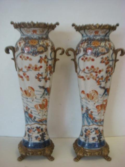 Pair of Porcelain and Brass Castalian Vases:: Pair of Porcelain and Brass Castalian Vases: Brass Lip on Slender Amphora Shape Vase with Broad Shoulder Tapering to Narrow Sculpted Foot. Set on Brass Fitted Plinth with Paw Feet. Double Curled Brass