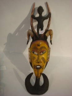 African Funeral Mask with Rams Horns:: African Funeral Mask with Rams Horns: Horns Connote the Practice of Sacrificing Rams to Mark Spirit Passing. Slit Placid Eyes. Horns Continue from Top of Head and Support Crudely Carved Male Figure.