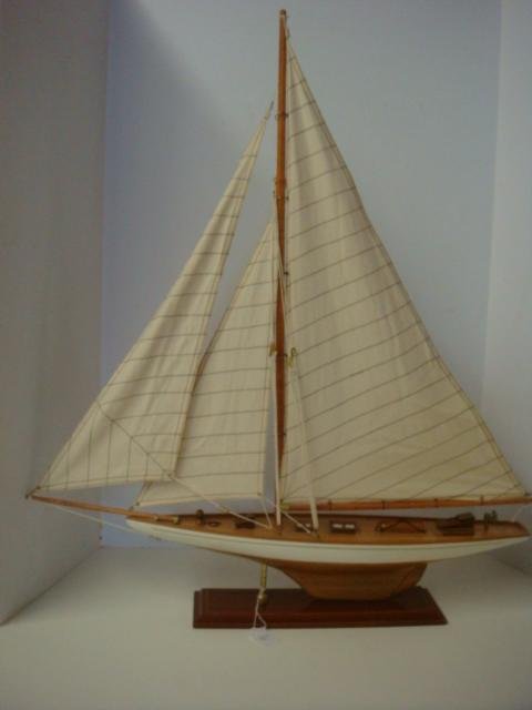 Wooden Model of White Hulled Racing Sloop: #2: Wooden Model of White Hulled Racing Sloop: #2 Brass Deck Fixtures, Full Sails, Long Bowsprit on Foredeck, 30'x 27" x 5". Brass and Wood Display Stand. (150-500)