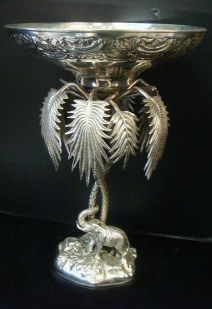 1960's Silver-plate Palm Tree and Elephant Center Bowl:: 1960's Silver-plate Palm Tree and Elephant Center Bowl: Large Stylized PALM Tree Supports 13"Dia. Bowl with Repousse Rim. Elephant Stands Below on Ground with Foliage. Stands 20"T on Ebonized, Biomorp