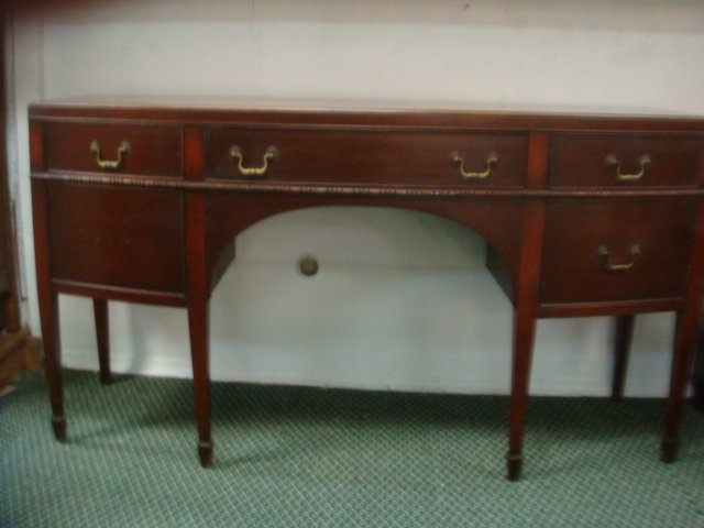 Mahogany Hepplewhite Bow Front Sideboard:: Mahogany Hepplewhite Bow Front Sideboard: Long Center Drawer Flanked by 2 Divided Utensil Drawers. 2 Doors with Single Interior Shelf. 6 Tapered Legs with Spade Feet and Arched Skirt. 37"T X 23"D X 68