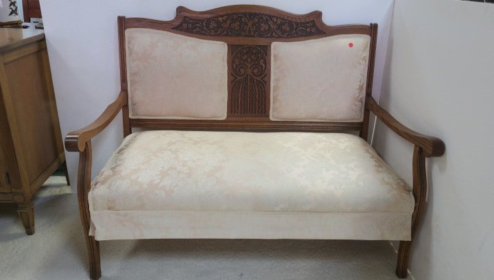 Oak Settee with Carved Crest Rail and Center Splat:: Oak Settee with Carved Crest Rail and Center Splat: Split Back with Cushion Upholstered Back and Seat. Shaped Arms with Scroll Hand rests. Carved Foliate Designs. Re-Upholstered in Light Green Gold Fl