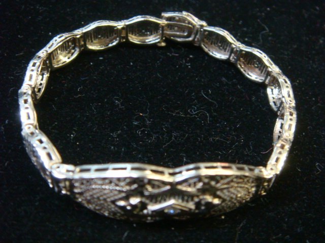 Edwardian/Deco 10KT Gold/Diamond Filigree Bracelet:: Edwardian/Deco 10KT Gold/Diamond Filigree Bracelet: 6 1/2"L. Die Cut Filigree Milgraining Lattices with Invisible Slide Clasp Marked 10KT. Center is Elaborate Trellis with Single Round Prong Set Diamo