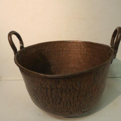 Antique Double Handled Hand Hammered Copper Pot:: Antique Double Handled Hand Hammered Copper Pot: Rounded Bottom, Rolled Edge. Riveted Wrought Handles. Hole at Bottom Side with Old Repair Marks. 10 1/2"T to Top of Handles, 14"D. (150-200)