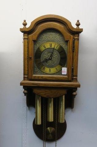 HERMLE German Wall Clock:: HERMLE German Wall Clock: Oak Case with Acorn Finials. Metal Face with Roman Numerals. Weight Driven. 32"T, 13 1/4"W. (-)