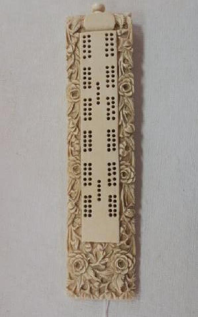 Hand carved Antique Bone Cribbage Board:: Hand carved Antique Bone Cribbage Board: 8"L with Threaded Knop at Squared End to Enclose the 6 Pegs. Deep Cut Relief Carved Roses and Leafy Tendrils Cover Surface. 5 Areas for Game Pegs on Either Sid