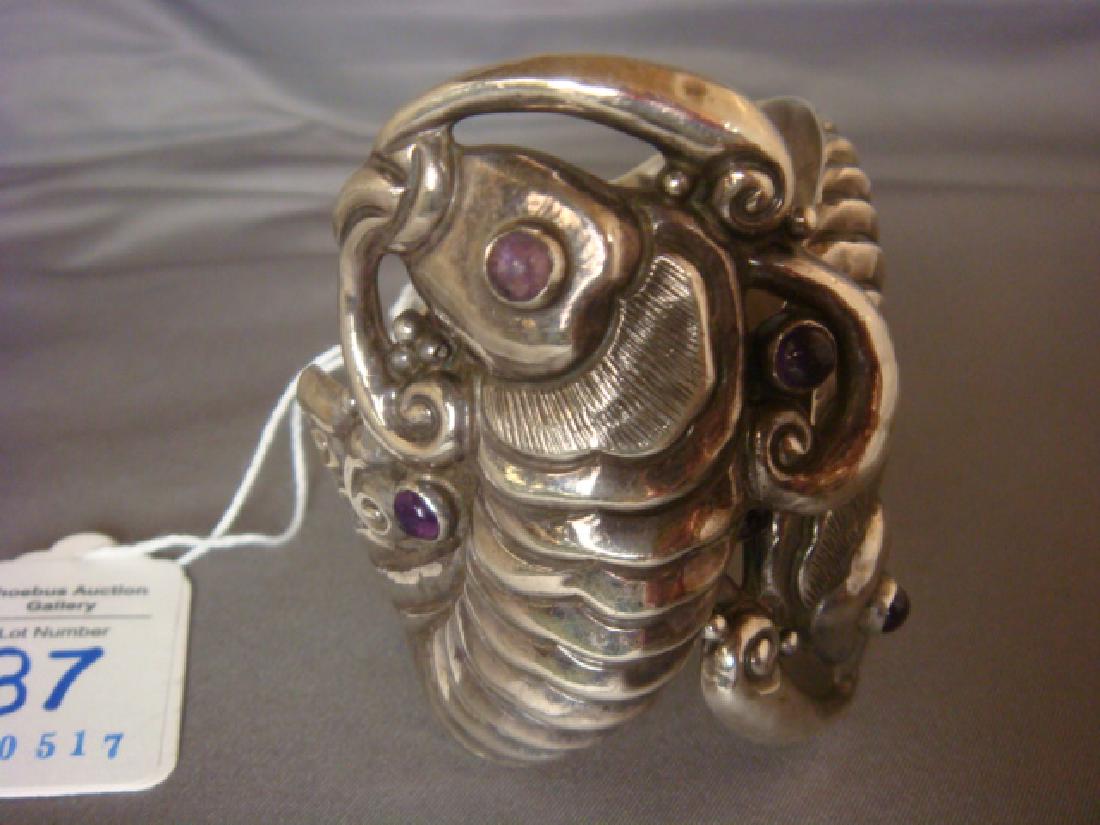 Handmade JOSE ANTON Hinged Sterling Fish Bracelet:: Handmade JOSE ANTON Hinged Sterling Fish Bracelet: Well Known Taxco Mexico Jeweler and Silversmith. Mythical Fish Have Cabochon Bezel Set Amethyst Eyes. Circa 1930, Pre Eagle Mark. 3"W (300-400)