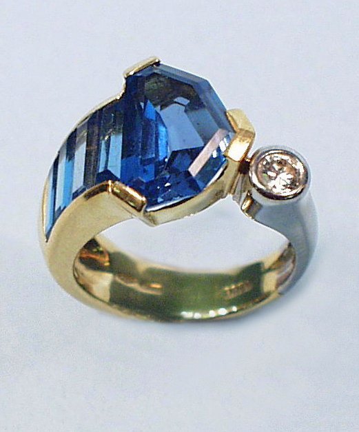 An unusual 18 kt. two tone gold ring set with fiel: An unusual 18 kt. two tone gold ring set with fields of facetted blue topaz and a brilliant cut diamond. Hallmarked.