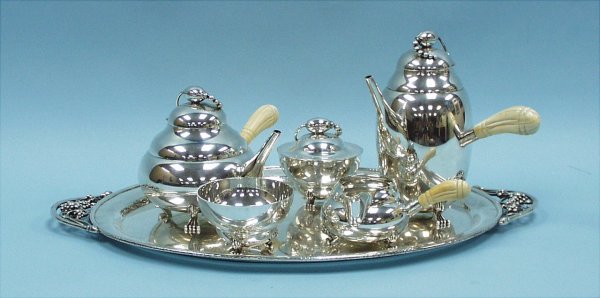 A Georg Jensen style "Blossom" pattern six piece s: A Georg Jensen style "Blossom" pattern six piece sterling silver coffee and tea service with ivory handles. Comprising a teapot, a coffee pot, a sugar bowl, creamer, bowl and tray. Each piece hallmark
