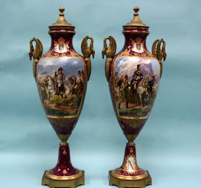 A pair of antique French gilt bronze mounted Sevre: A pair of antique French gilt bronze mounted Sevres porcelain Napoleonic urns. Handpainted by Chanele on maroon ground with scenes of Wagram 1809 and Rivoli 1797. Signed. Appx. 70 cm high.