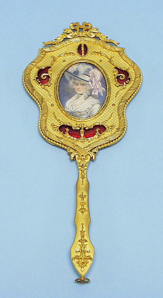An unusual antique French Louis XV style gilt bronz: An unusual antique French Louis XV style gilt bronze framed hand mirror. The serpentine sided frame with tied ribbon mountings. Reverse with a framed ivory portrait within enamel borders. 11 1/2" long
