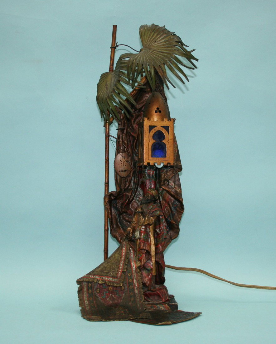 FRANZ BERGMAN - A very good Austrian polychrome pat: FRANZ BERGMAN - A very good Austrian polychrome patinated orientalist lamp. Modelled with the figure of a carpet merchant displaying his wares. 20" high. Stamped model number and mark.