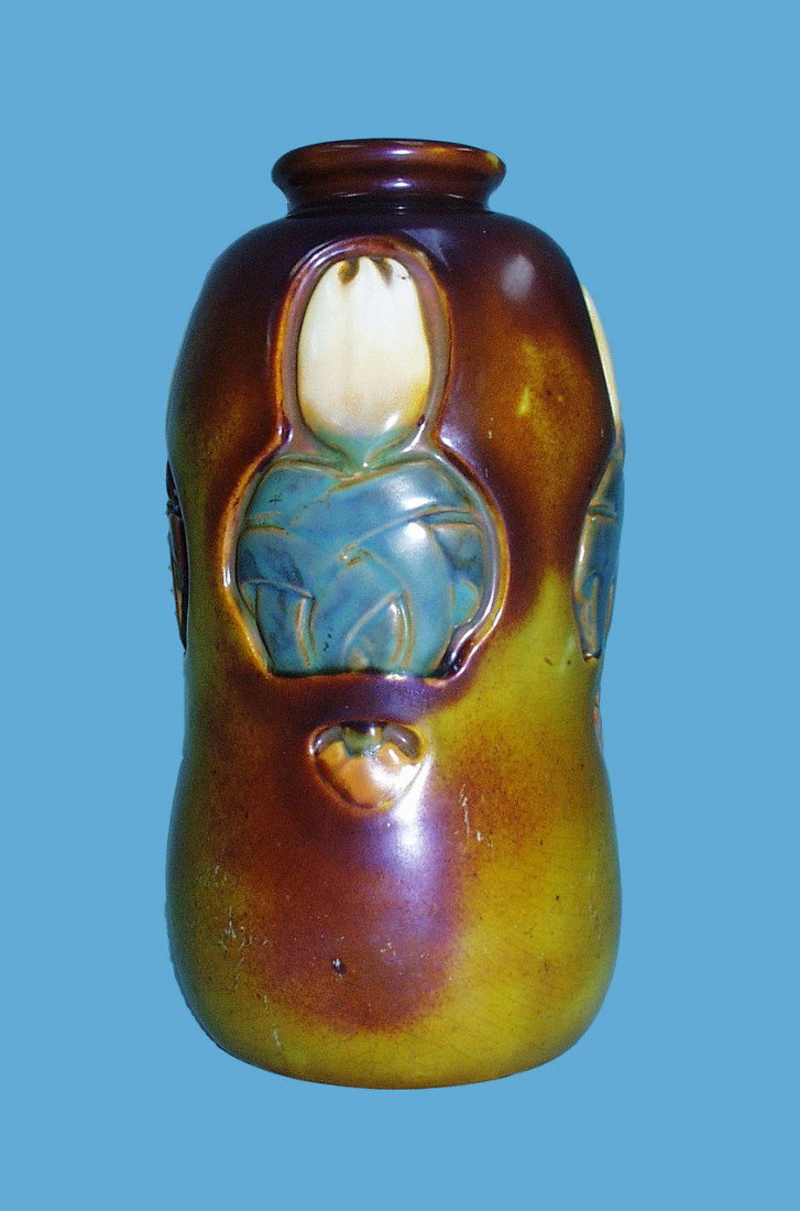 ZSOLNAY, PECS. A hand painted hour glass shaped va: ZSOLNAY, PECS. A hand painted hour glass shaped vase decorated with white tulips on an iridescent purple and ochre ground. Marked underside. 7 1/2" high. Circa 1930.