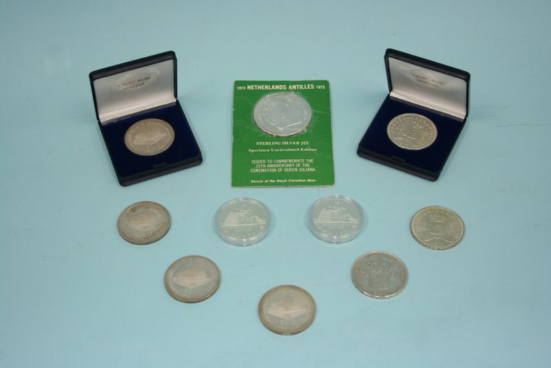 A lot comprising 10 silver coins: two uncirculate: A lot comprising 10 silver coins: two uncirculated, encased Canadian silver dollars, four boxed Dutch Antilles 50 gulden pieces, two Dutch Antilles 10 gulden pieces, one Dutch Antilles (Curacao) 2 ½