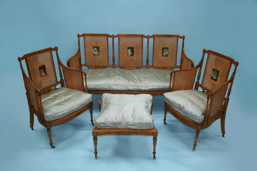 A good four piece Edwardian satinwood salon s: A good four piece Edwardian satinwood salon set consisting of a sectional settee, two armchairs and matching ottoman. All pieces delicately handpainted with Belle Epoque motifs and with period cane ba