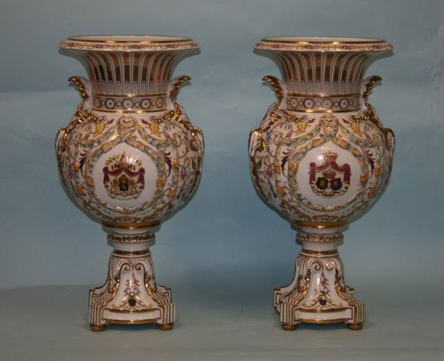 A pair of early 20th century French Sevres porcel: A pair of early 20th century French Sevres porcelain floor vases. Each baluster with square matching base. Hand painted on two medallions with "coat of arms" in floral white and gilt field. Hallmarked
