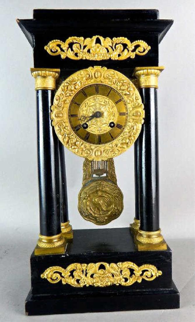 Gilt Bronze Empire Ebony Mantle Clock: Circa 1830 restored and in working order, has pendulum and measures 16" x 8" x 5". Estimate $800 - $1,200 Starting Bid $100
