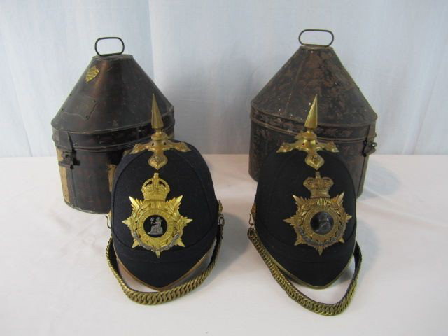 A3-18 TWO VINTAGE SCOTLAND YARD DRESS HATS: In original metal boxes. Inside of helmets "Hobson & Sons London". Badges on front of helmets "Norfolk Regime" one with Esq. and one with Captain. Names are illegible.