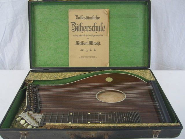 C98-4 VINTAGE GERMAN MUSICAL INSTRUMENT: With case and sheet music book. Estimate $100 - $200