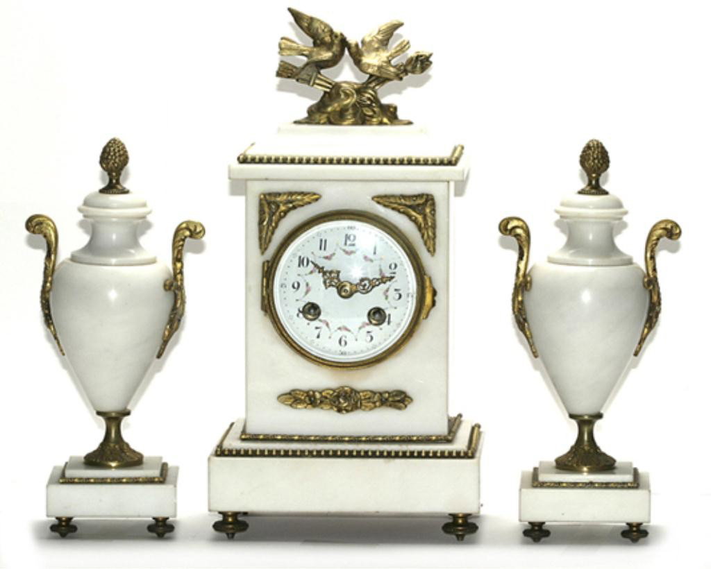 F60-48 WHITE MARBLE & BRONZE CLOCK SET: The clock is decorated with two kissing doves on top,with a beautiful dial hand painted enameled with swags of flowers, with 2 matching urns to the clock. The clock measures 12.5"Hx6"Wx4.5"D and urns 