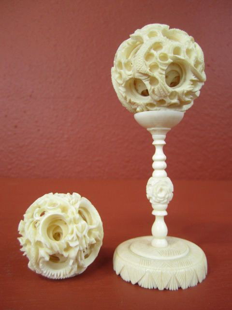 F27-25 TWO IVORY MYSTERY BALLS: With one pedestal. Measures 5 1/8" tall. Estimate $100 - $300