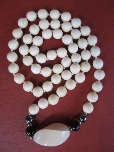 A26-8 IVORY NECKLACE: With 1/2" round beads with gold, hematite and onyx with carved center piece. Measures 32" long. Estimate $300 - $600