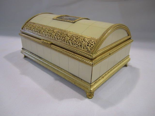 F57-2 ITALIAN IVORY MUSIC BOX: Hand painted portrait on top with gold trim and red velvet lining. Marked on bottom "Made in Italy". Measures 3 1/2" tall x 7 3/4" wide x 5" deep. Estimate $1,000 - $1,800