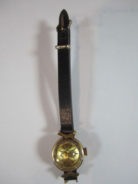 E17-6 LADIES TISSOT 18K GOLD WRIST WATCH: With leather band and faceted glass. Estimate $100 - $200
