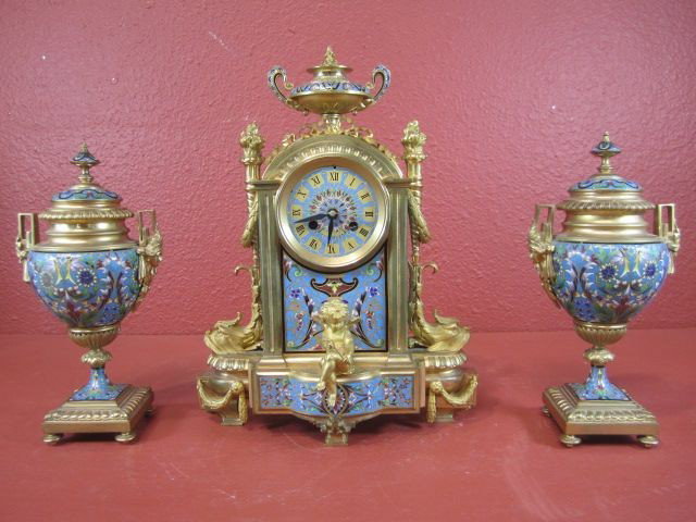 A11-68 CHAMPLEVE 3-PC CLOCK SET: Battery operated. Clock measures 14" tall. Garnitures measure 10 1/2" tall. Estimate $6,000 - $9,000