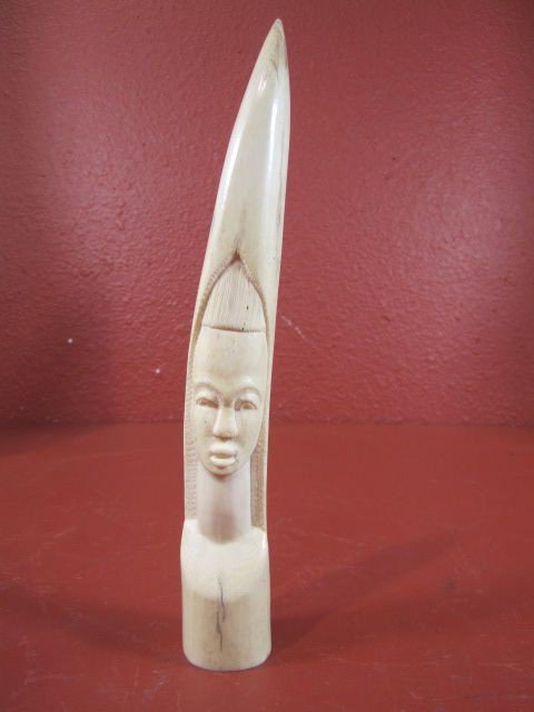 A71-5 CARVED IVORY TUSK: With carved image of a lady's face. Measures 9 1/4" in length. Estimate $100 - $300