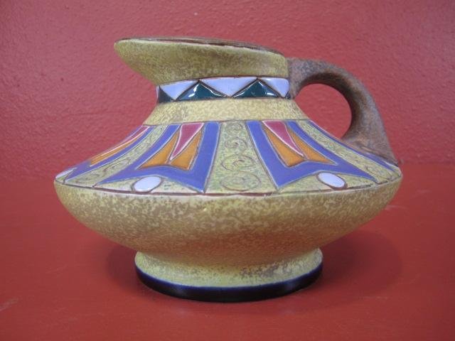 G37-4 MULTI COLORED POTTERY PITCHER: Marked "XIV" on bottom. Measures 5 1/2" tall x 8" diameter. Estimate $100 - $300
