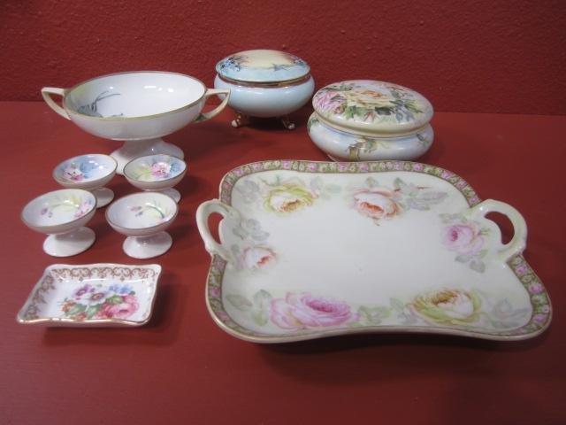 E77-9 LOT OF 9 FINE CHINA ITEMS: Including French powder box, Austria footed powder box, Bavaria dessert platter, small Staffordshire tray, Nippon double handles pedestal dish, and 4 Nippon egg holders. Estimate $100 - $200 Starting 