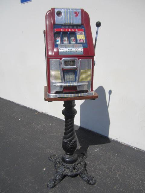 E90-4 1960 MILLS 5 CENT SLOT MACHINE: With stand. All in original condition. Estimate $1,000 - $1,500 Starting Bid $700