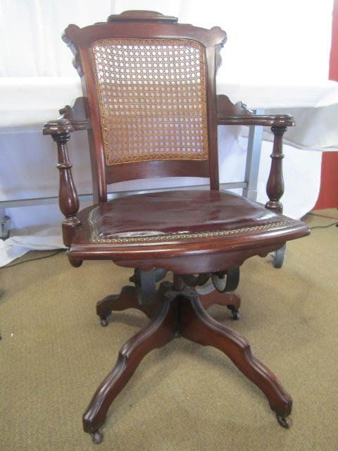 A19-42 ANTIQUE VICTORIAN WALNUT DESK CHAIR: Swivel base and caned back. Estimate $200 - $400 Starting Bid $75