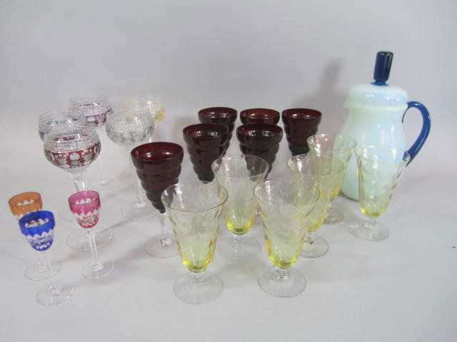 H25-38 COLLECTION OF GLASSWARE: Including hand blown blue pitcher with lid 12" , 5 Czechoslovakian wine glasses 8 1/4", 3 Baccarat colored stemware 5", 6 red wine glasses 7", and 6 yellow glasses 6". Good condition. Estimate $200 -