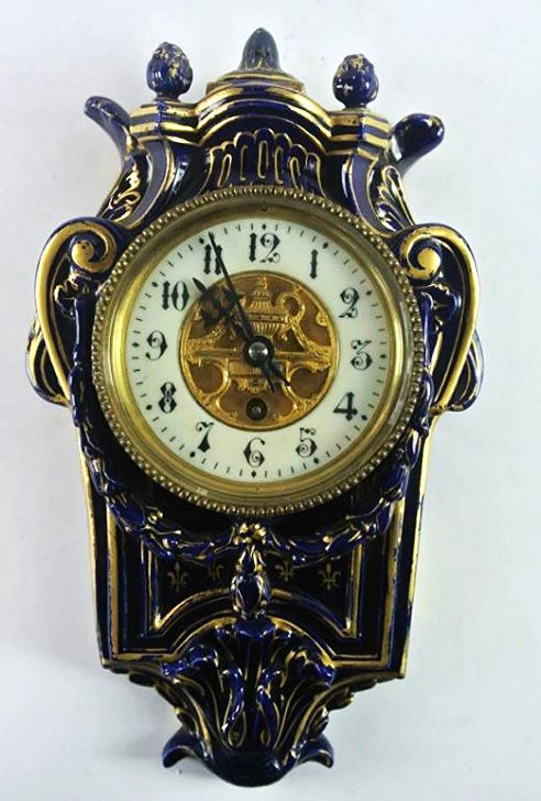 H25-11 PORCELAIN COBALT AND GOLD WALL CLOCK: Measures 13" tall. Estimate $200- 300. Starting Bid $20. 12550