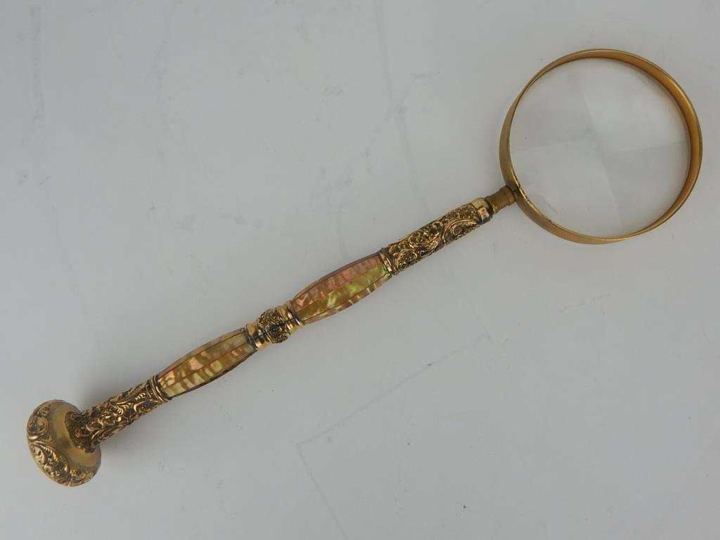 K13-40 DECORATED INLAID MAGNIFYING GLASS: Silver gilt and mother of pearl handle. Measures 13 1/2" Estimate $500 - $600 Starting Bid $200
