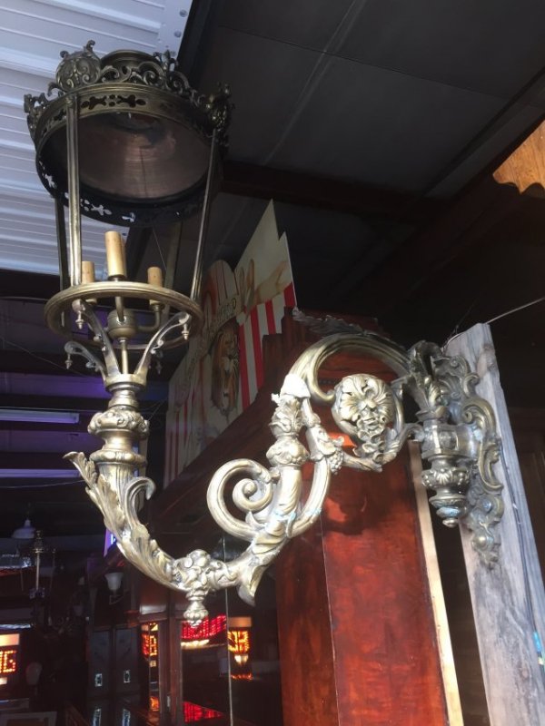 Pair of Monumental Brass and Iron Sconces: A pair of monumental single arm bronze sconces with brass lantern heads. 64"h x 45"w