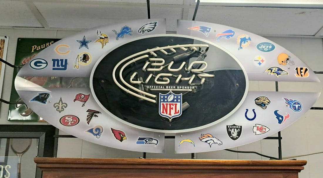 Bud Light Football Neon: Bud light football shaped neon with NFL team names added to the background. circa 1960's