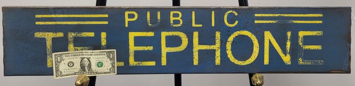 A Blue And Yellow Metal Public Telephone Sign