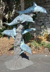 4 dolphins swimming around a reef in bronze with 2 patinas, piped for fountain use. 80"h x 46"w x
