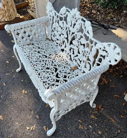 Cast iron garden bench with floral design and rams heads on the arm rests. 37" H x 43" W 34" D