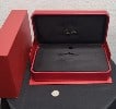Classic high end jewelry Cartier watch case on their typical red and gold decor.