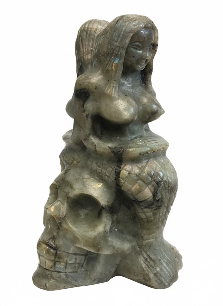Hand Carved Labrodorite Statue Depicting 2 Mermaids Bare Breasted on top of Skull: Carved Bare Breasted Mermaids atop a Skull. Etched Details and Measures: 9"H x 7"W x5"D