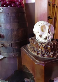 Small Skull with Intricate Carving on Wooden Carved Display Case. 8"H x 5"W x 8"D.