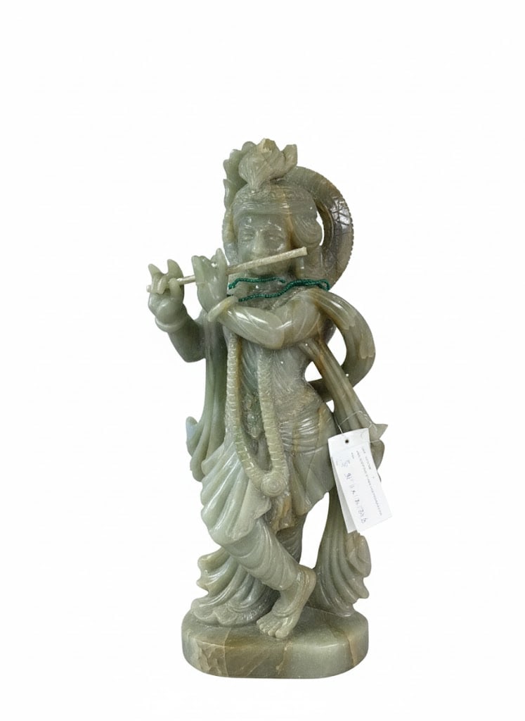 Jade Statue of Hindu God Krishna - 31"Tall: This is a large, intricately carved sculpture made of pale green-to-grayish-green jade, identified as a JADE SCULPTURE OF HINDU GOD KRISHNA.Krishna is shown standing on a lotus base, playing the flute