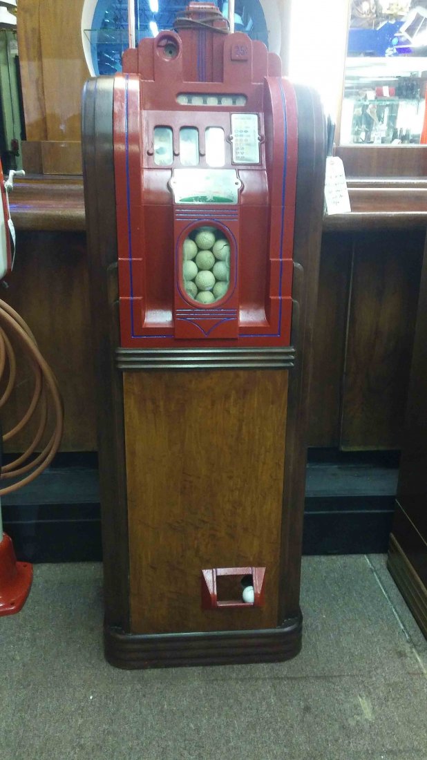 25 cent Mills golf ball upright console slot vendor: slot machine style golf ball vendor, pull to get jackpot, depicting grapes, bells, cherries, lemons and oranges (60"H x 22"W x 13"D)
