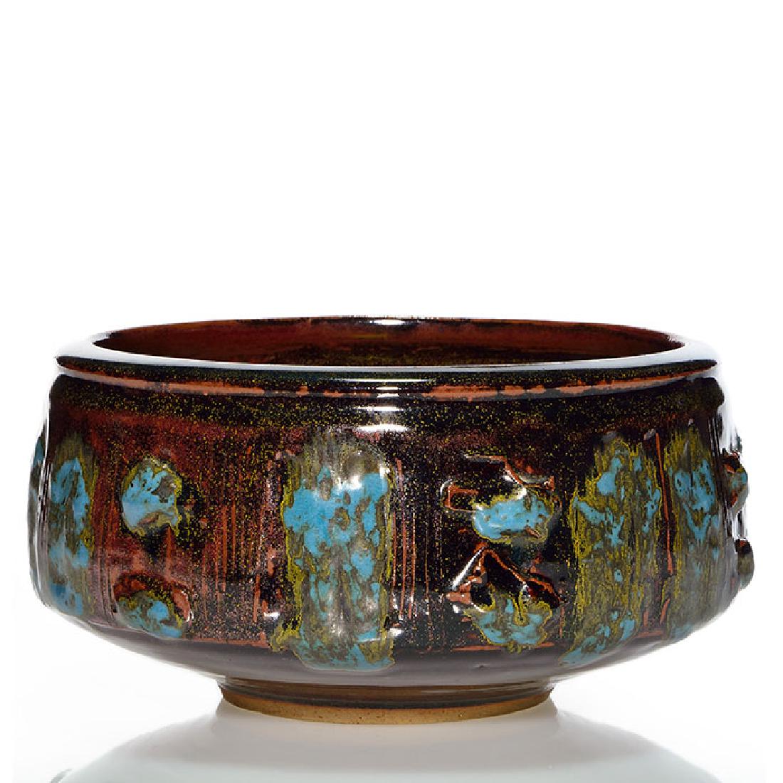 Vivika & Otto Heino bowl, 4 1/4” x 8 1/2”: Vivika & Otto Heino bowl with incised and modeled decoration and covered with a brown crystalline glaze with blue and yellow highlights. Incised Vivika + Otto. Size is 4 1/4 inches high and 9 inches w