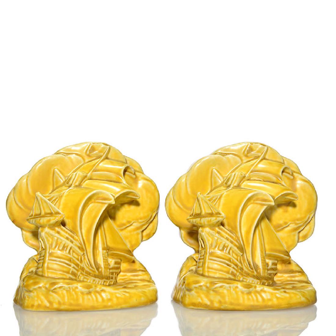 Rookwood full sail ship bookends, 1924,2695, 5 1/2: Pair of Full Sail Ship bookends, a William McDonald design, cast in 1924 and covered in a yellow mat glaze. Marks include the Rookwood logo, date, shape 2695 and Mr. McDonald’s mold monogram. There